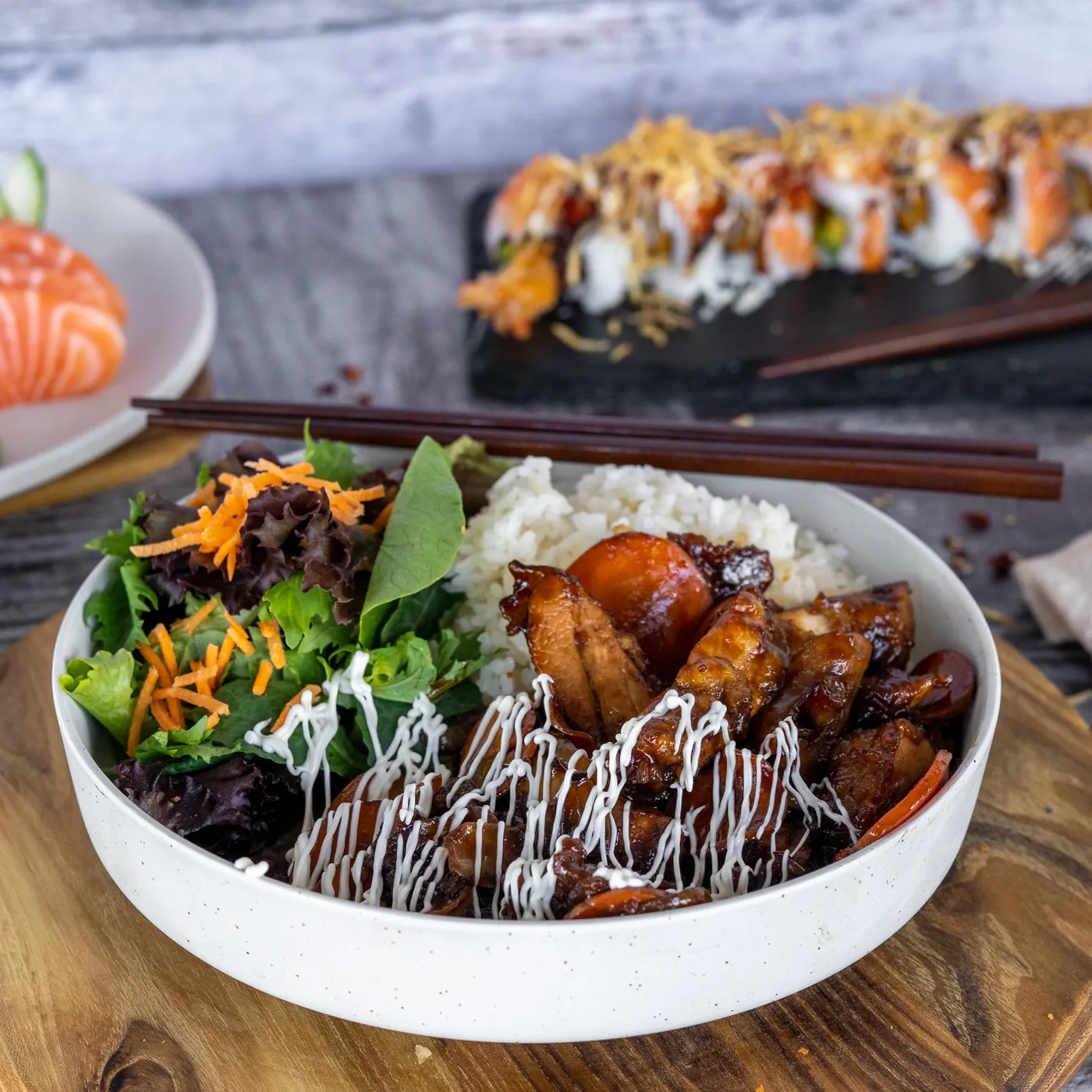 A Sushi Ari rice bowl topped with chicken and fresh vegetables